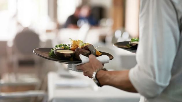 Un camarero sirviendo un plato en un restaurante