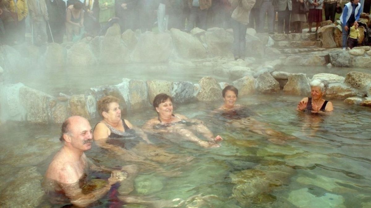 Varias personas mayores disfrutan de una piscina termal