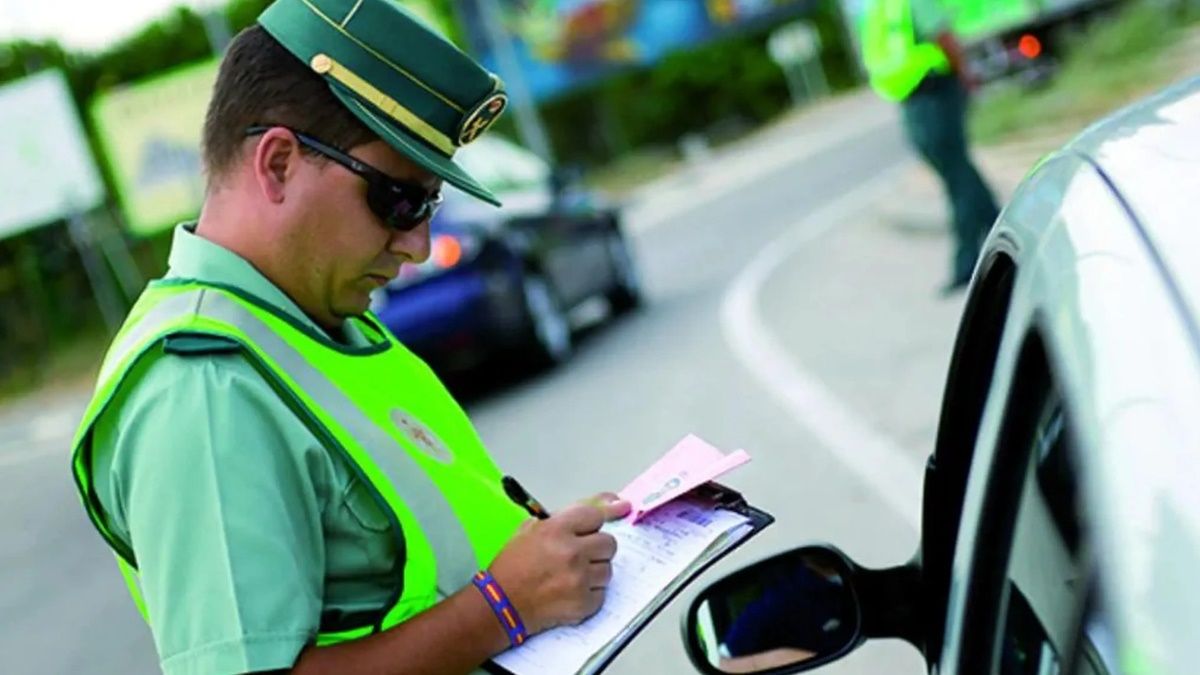 Cuidado con no pagar las multas de tráfico: Hacienda avisa de que podrá embargar tu nómina Un agente de la Guardia Civil pone una multa al conductor de un coche
