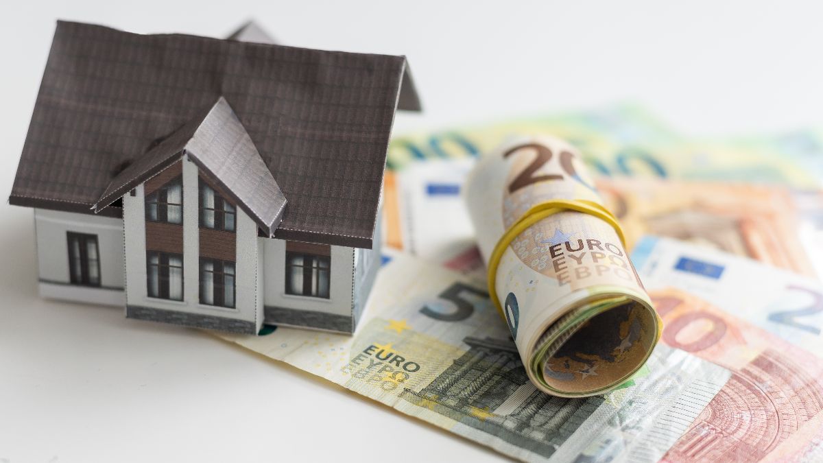Una casa junto a billetes de euro Una casa junto a billetes de euro