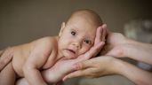 manos de padres sosteniendo a un bebe