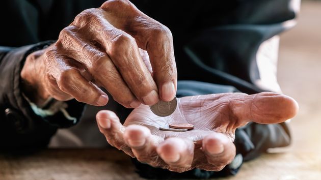 Manos de un anciano contando dinero