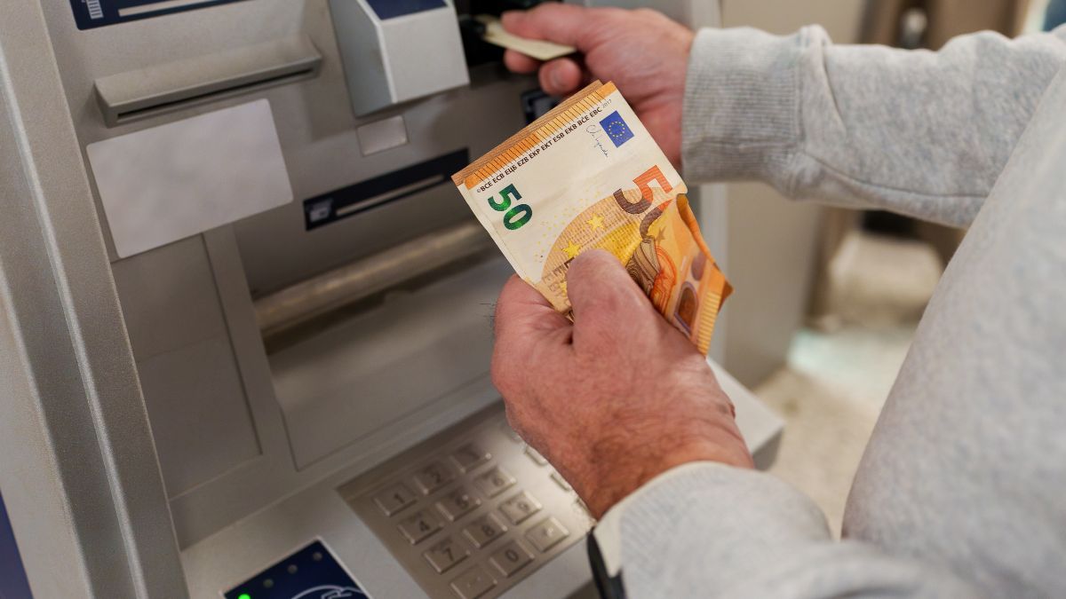 Una persona sacando dinero de un cajero automático Una persona sacando dinero de un cajero automático