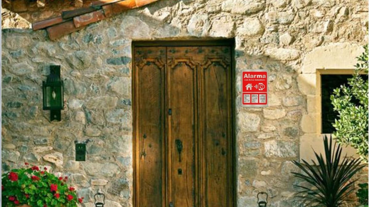Fachada de una casa con un cartel de alarma Fachada de una casa con un cartel de alarma