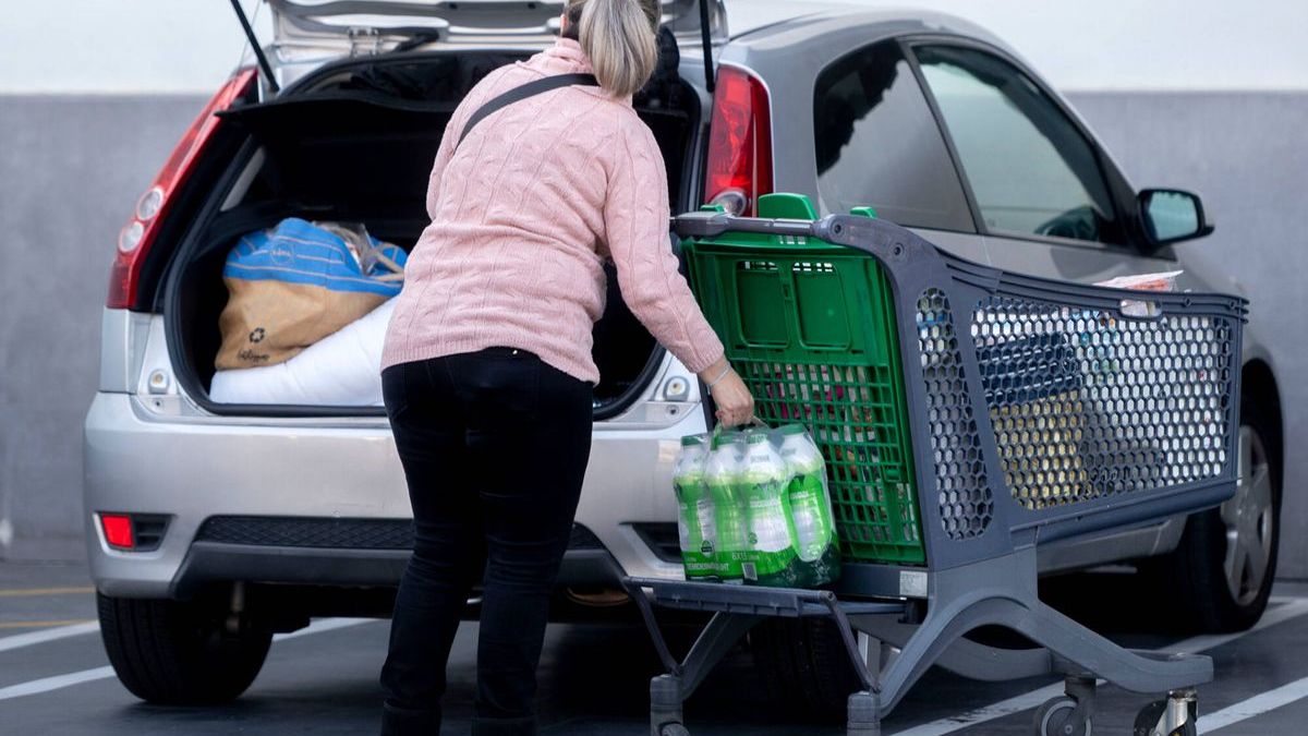 Una mujer descargando la compra en el coche
