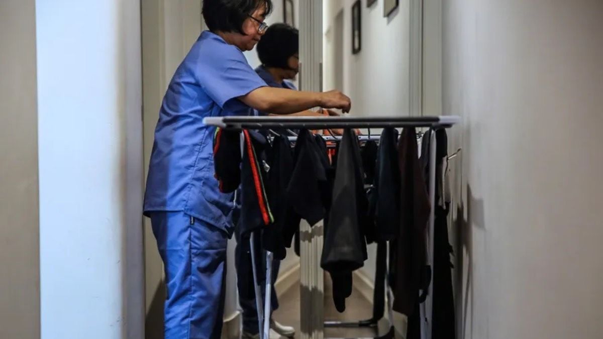 Empleada del hogar, durante su jornada, tendiendo ropa Empleada del hogar, durante su jornada, tendiendo ropa