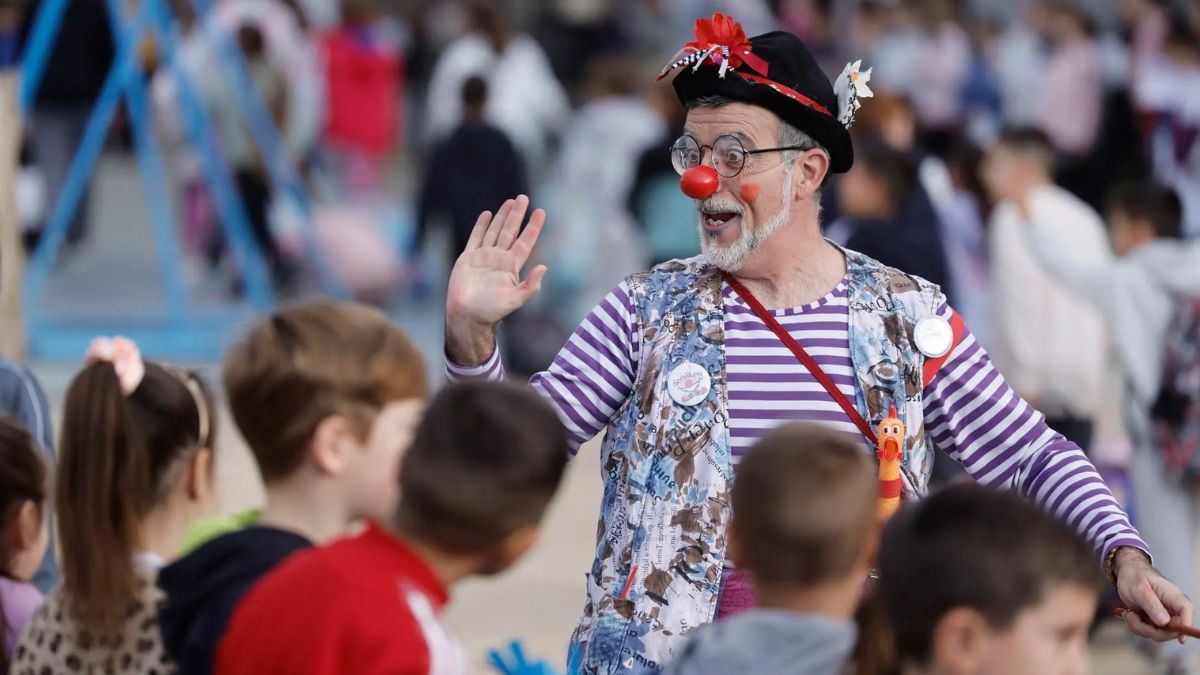 Un payaso saluda a varios niños en un colegio