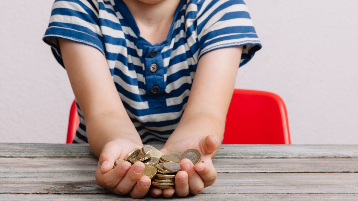 Un niño pequeño con monedas de euro