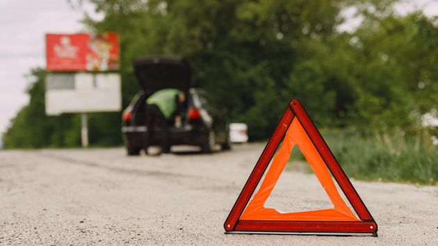Triángulo en una carretera señalizando la incidencia en un coche