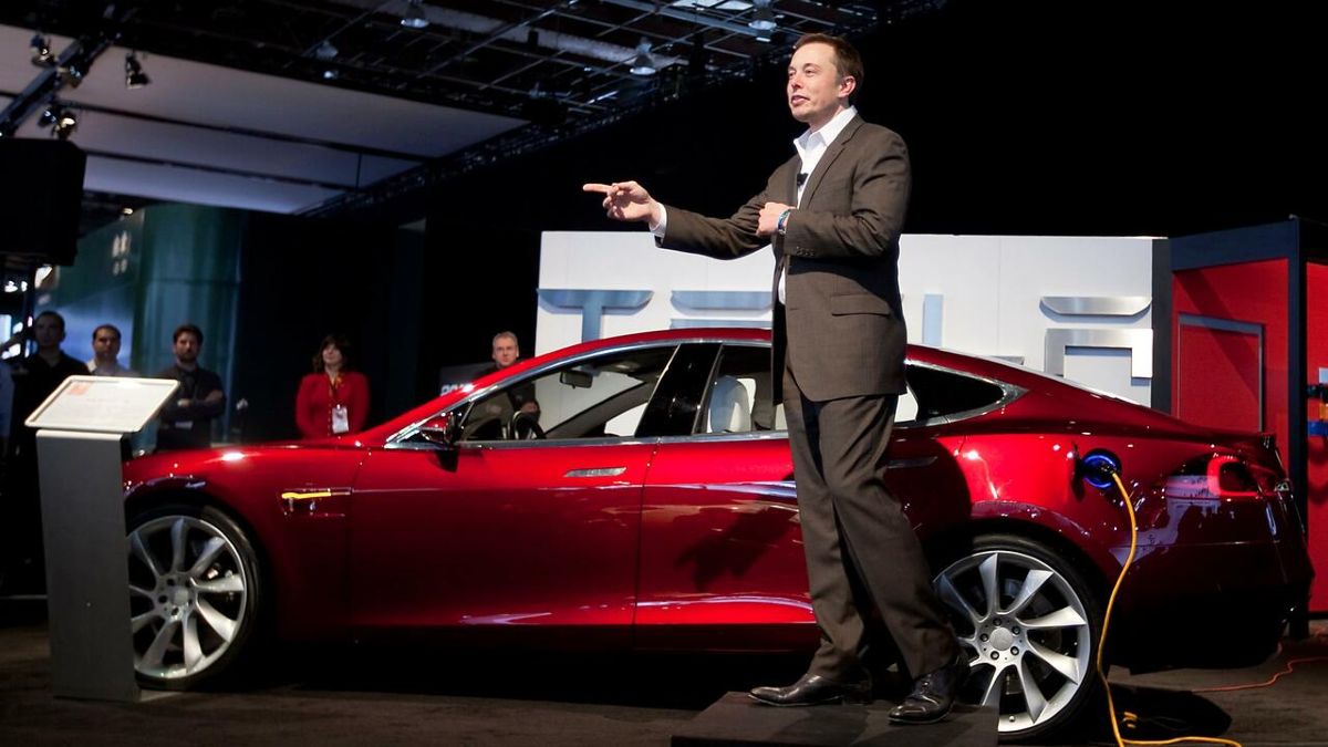 Elons Musk con un Tesla