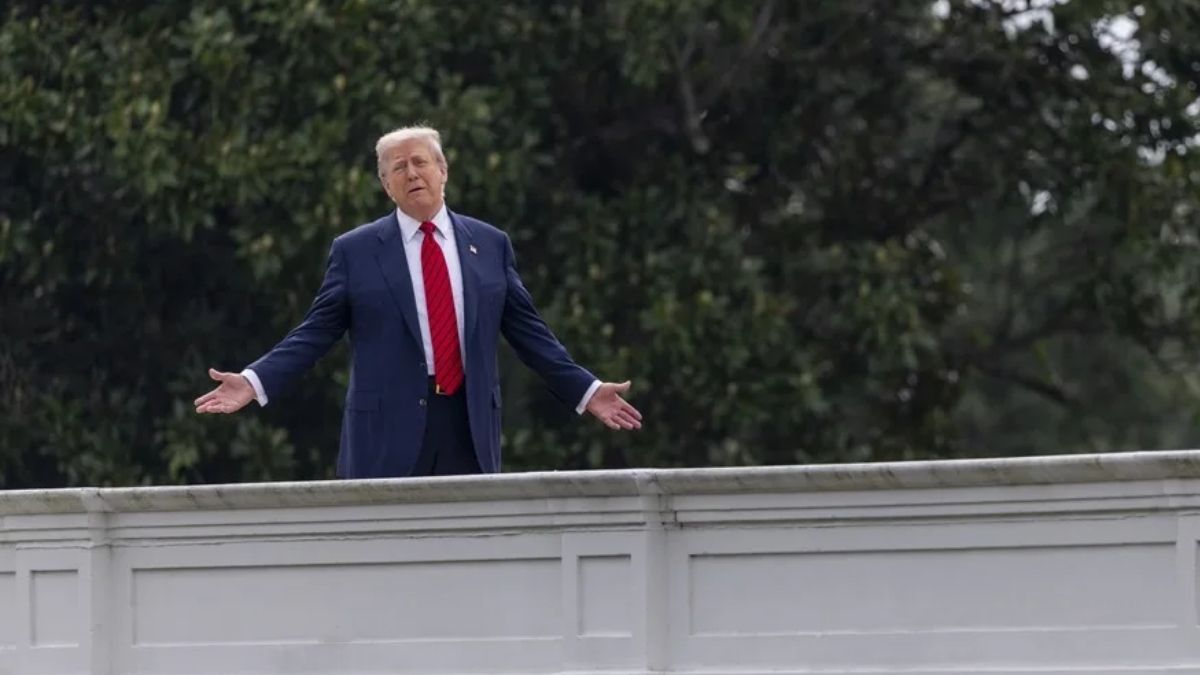 Donald Trump con los brazos abiertos sobre un puente