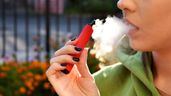 Una mujer vapeando en una terraza