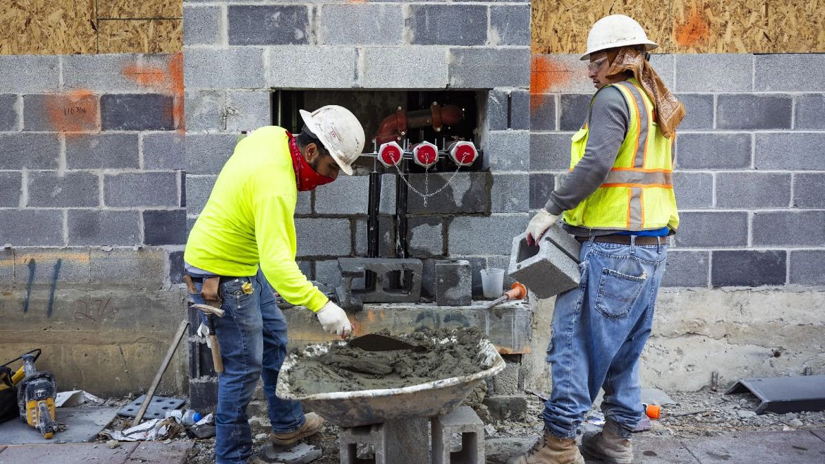 Dos peones de albañil trabajando