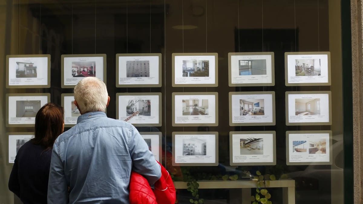 Dos personas observan el escaparte de una agencia inmobiliaria en Madrid