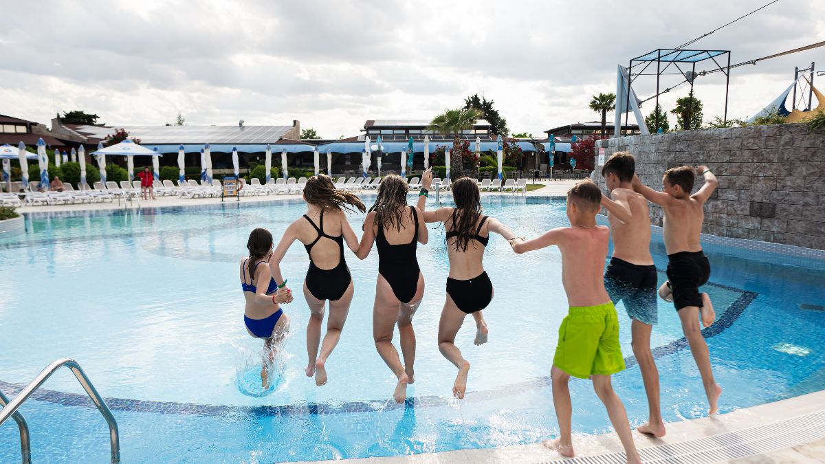 Unos niños tirándose a la piscina