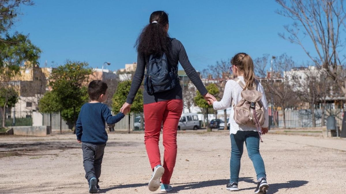 Una madre pasea con dos hijos