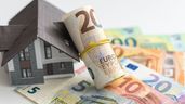 Billetes de euro junto a la figura de una vivienda 
