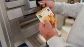 Una persona sacando dinero del cajero