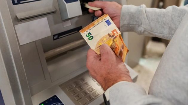 Una persona sacando dinero del cajero