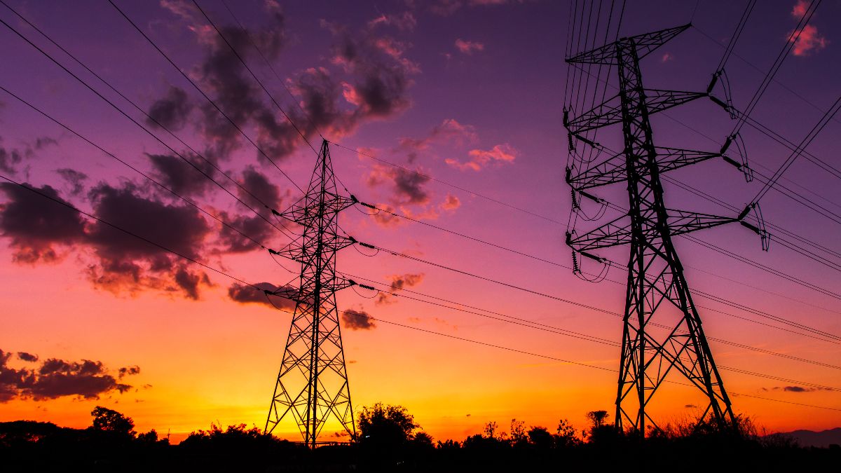 Dos torres eléctricas bajo un atardecer