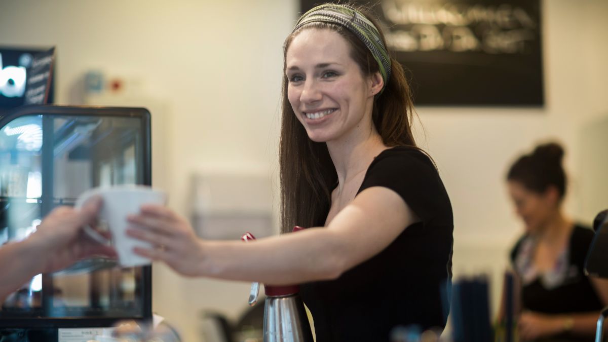 Una camarera sirviendo un café