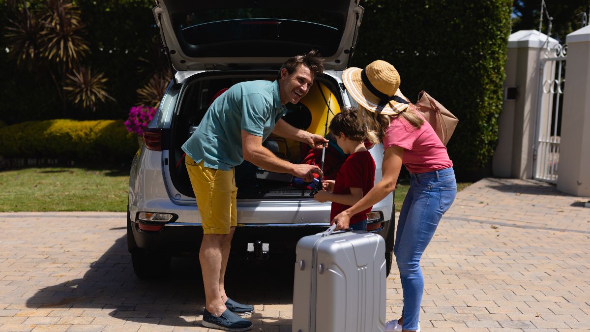 Una familia metiendo maletas en el coche 