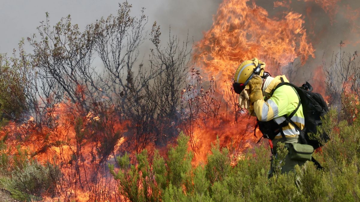 Un bombero se sujeta el casco en el incendio de Yeres