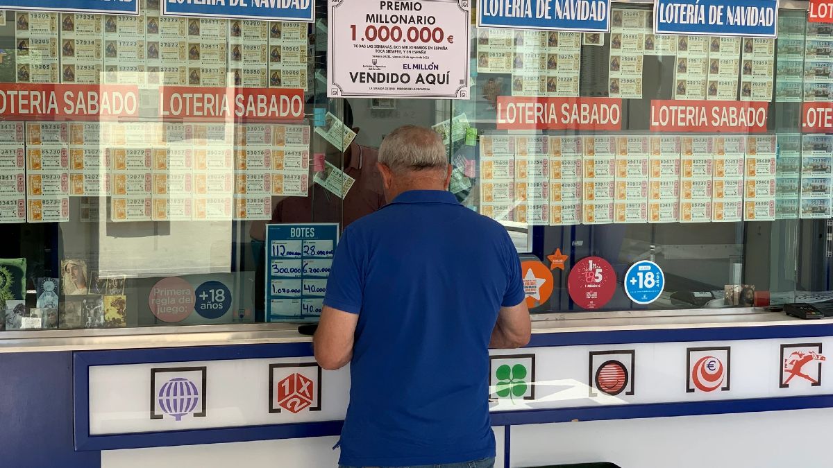 Un hombre comprando lotería en una administración