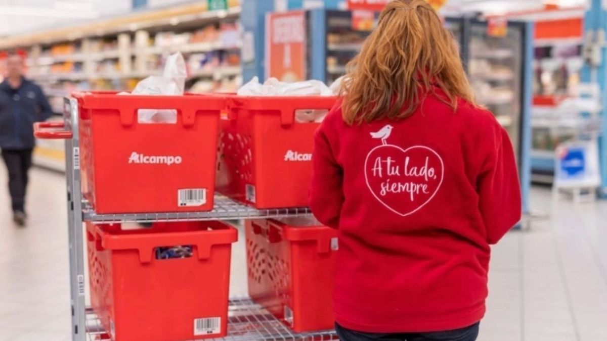 Una trabajadora de Alcampo con un dispositivo electrónico