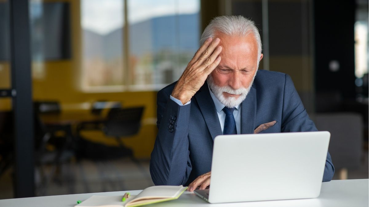Trabajador sénior sentado delante del ordenador
