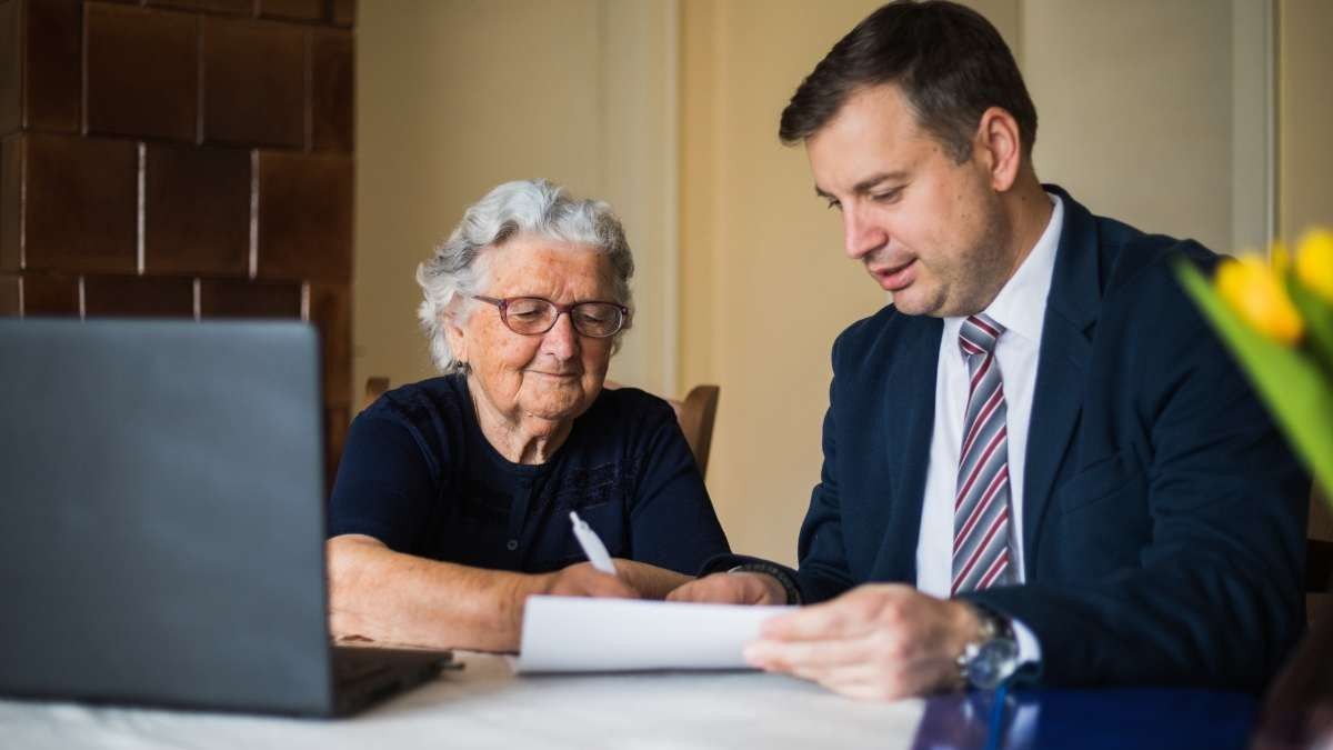 Una anciana firmando un documento