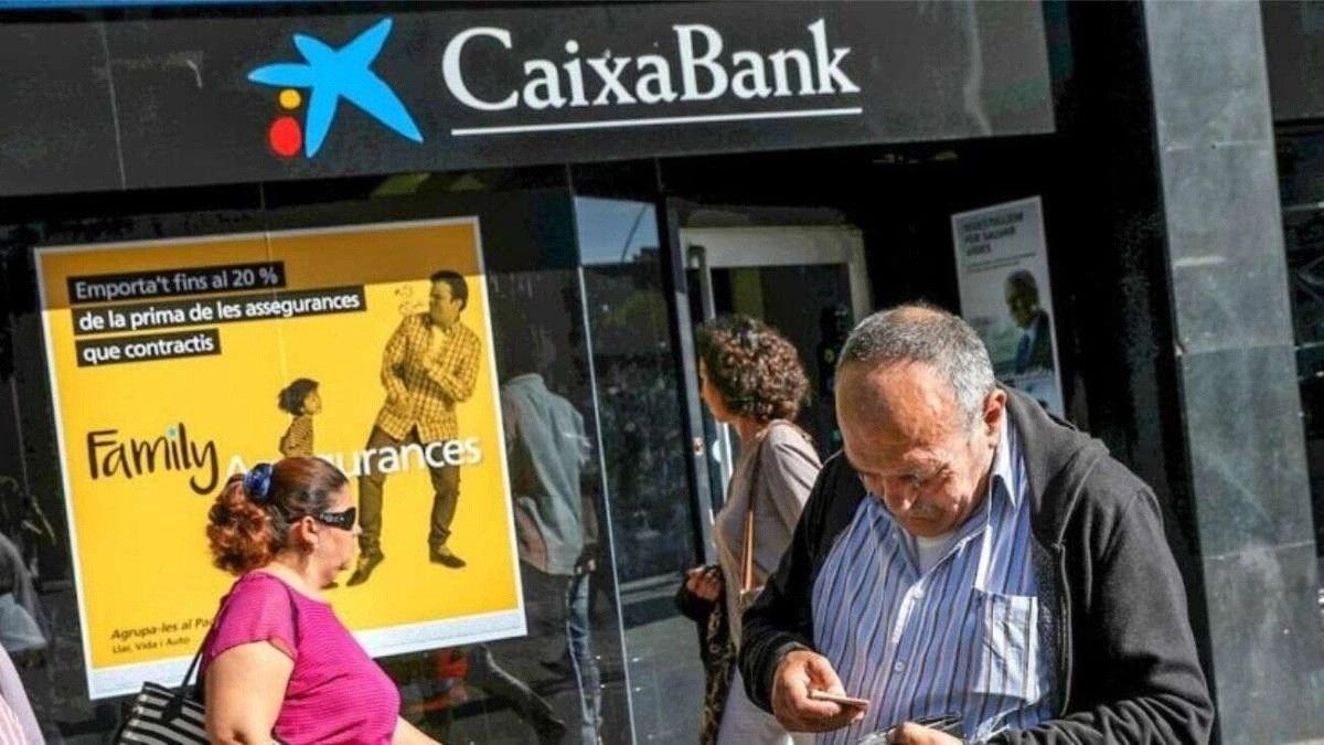 Varias personas delante de la oficina de CaixaBank