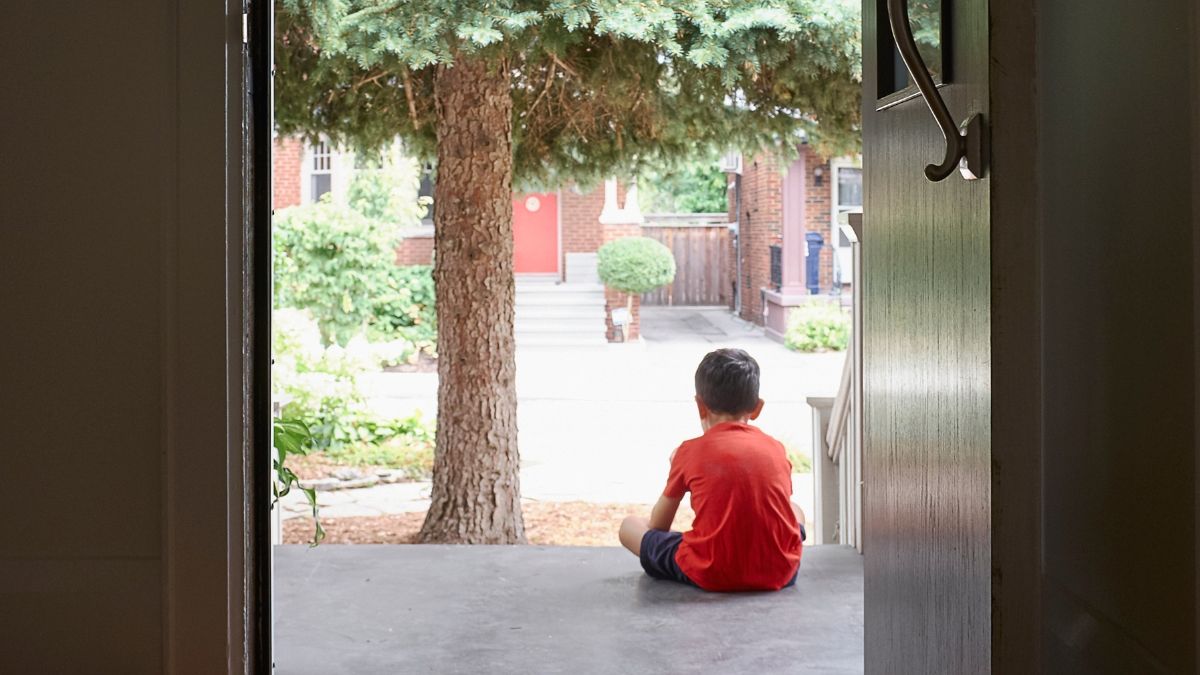 Un niño espera en la puerta del colegio