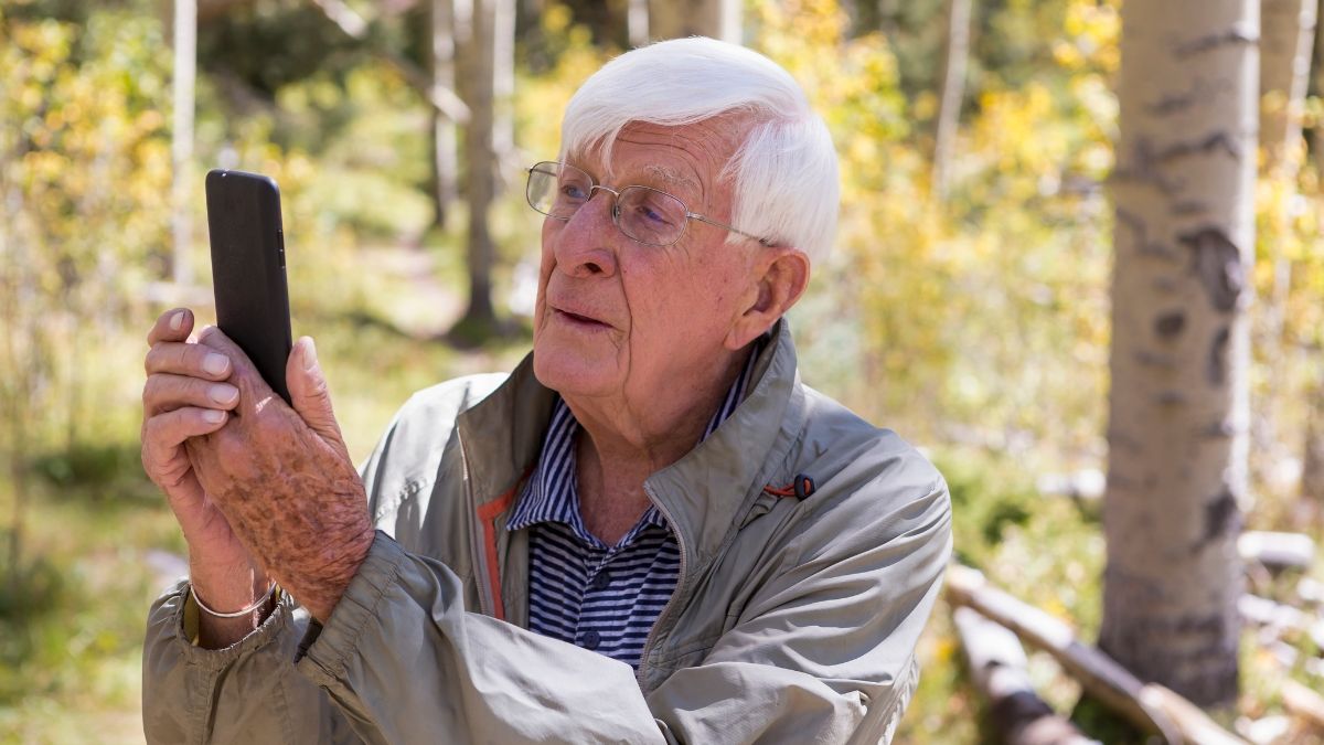 Un anciano mirando su teléfono móvil
