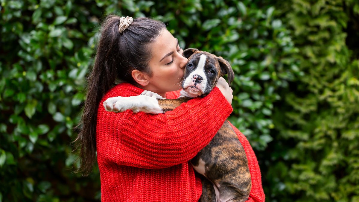 Una joven abrazando a su perro cachorro