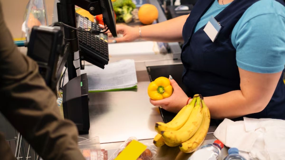 Manos de una cajera de supermercado cobrando la compra