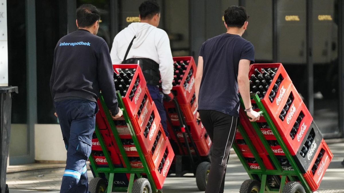 Unos trabajadores cargando con bebidas