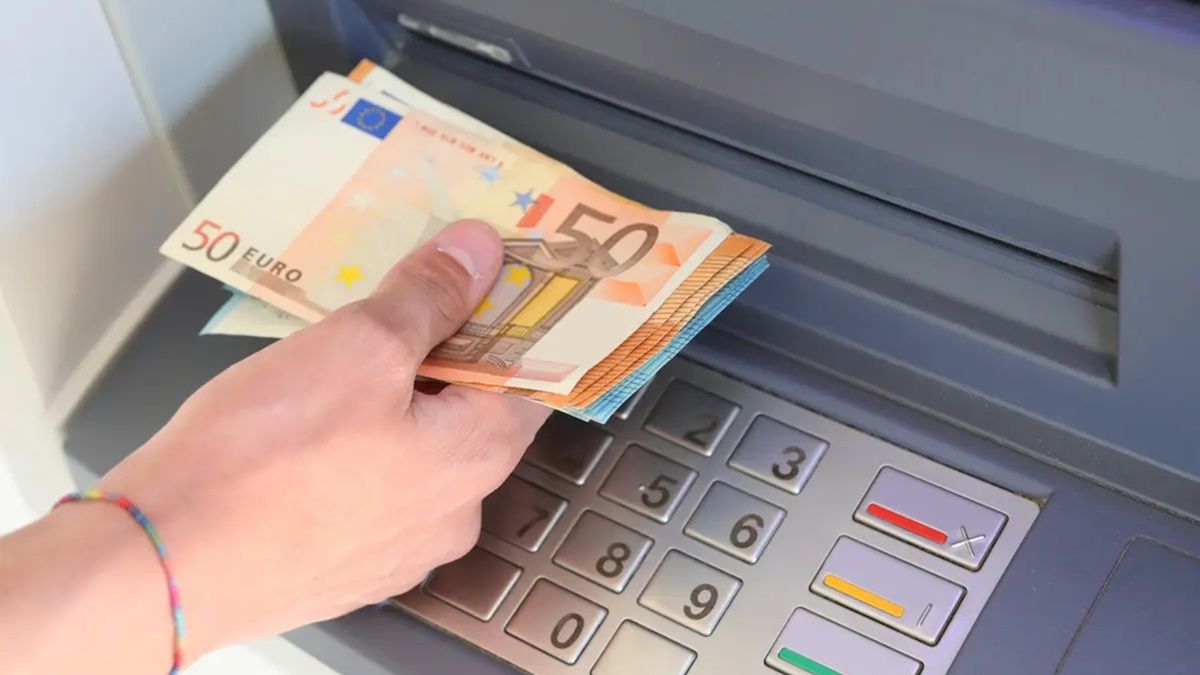 Una persona sacando dinero de un cajero