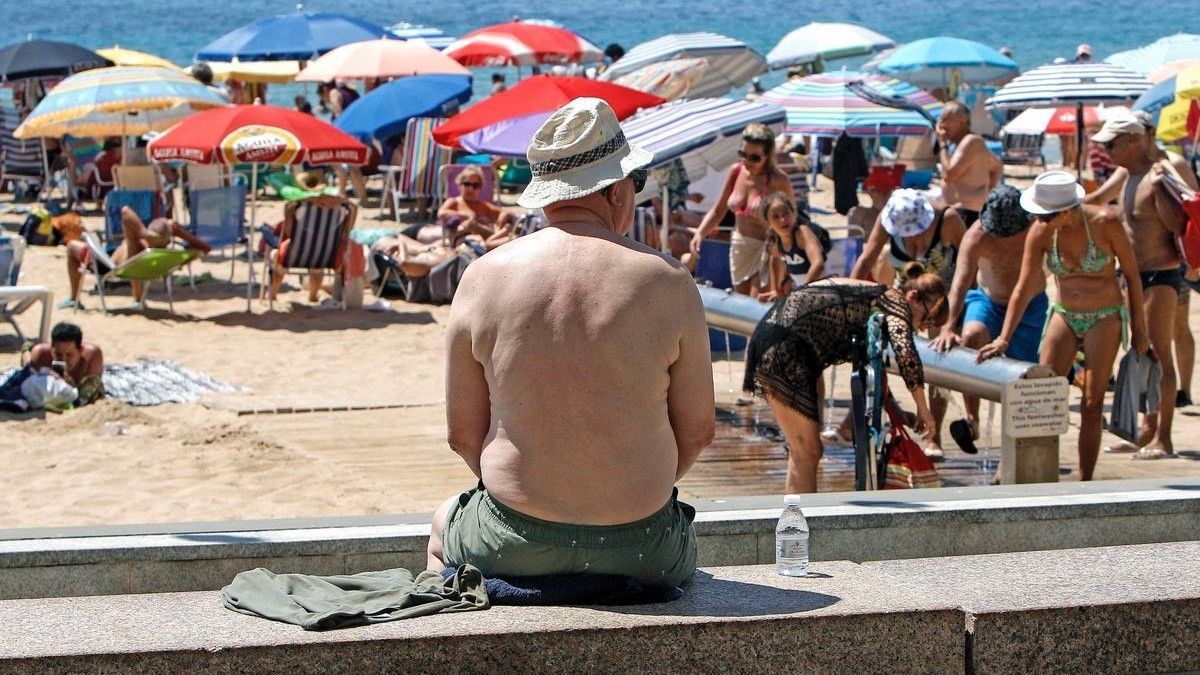 Un hombre con sombrero mira a la playa