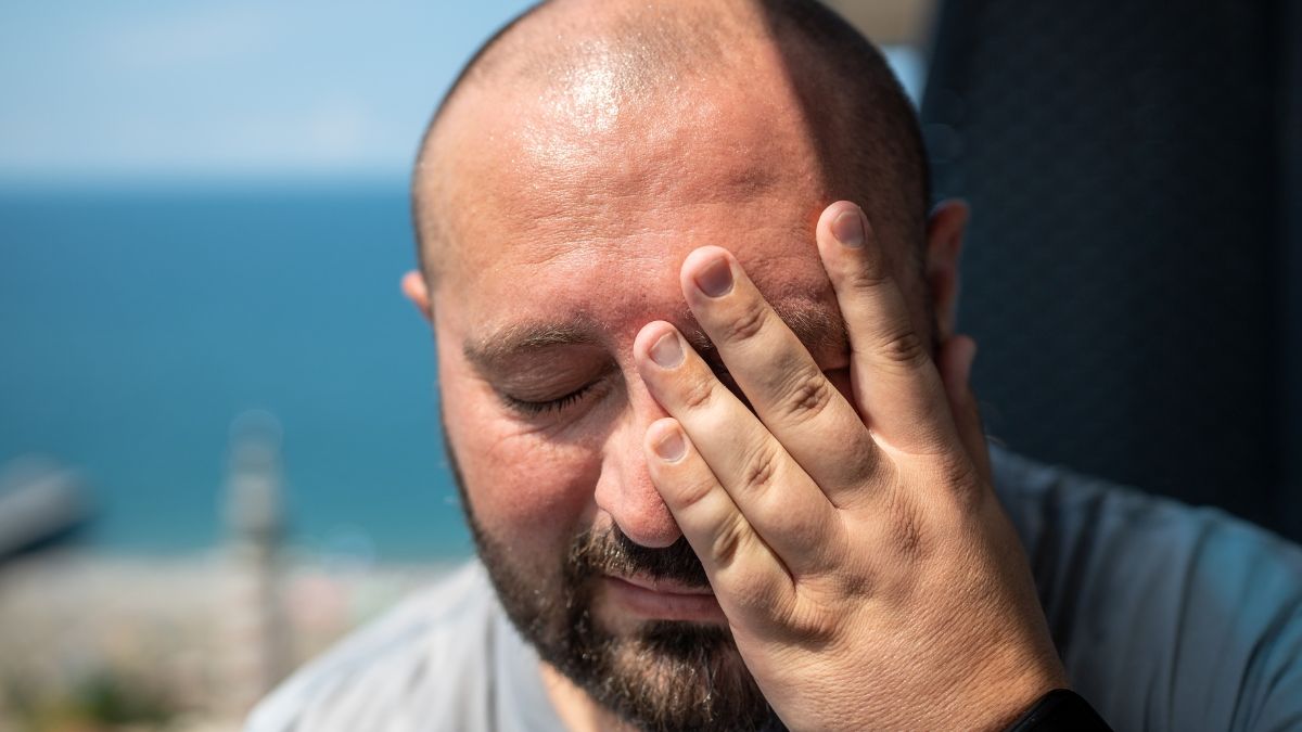 Un hombre llorando con la mano en la cara