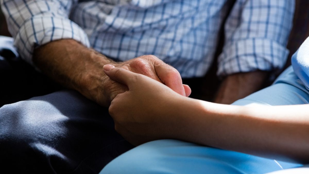 Mano de una chica joven con la de un anciano