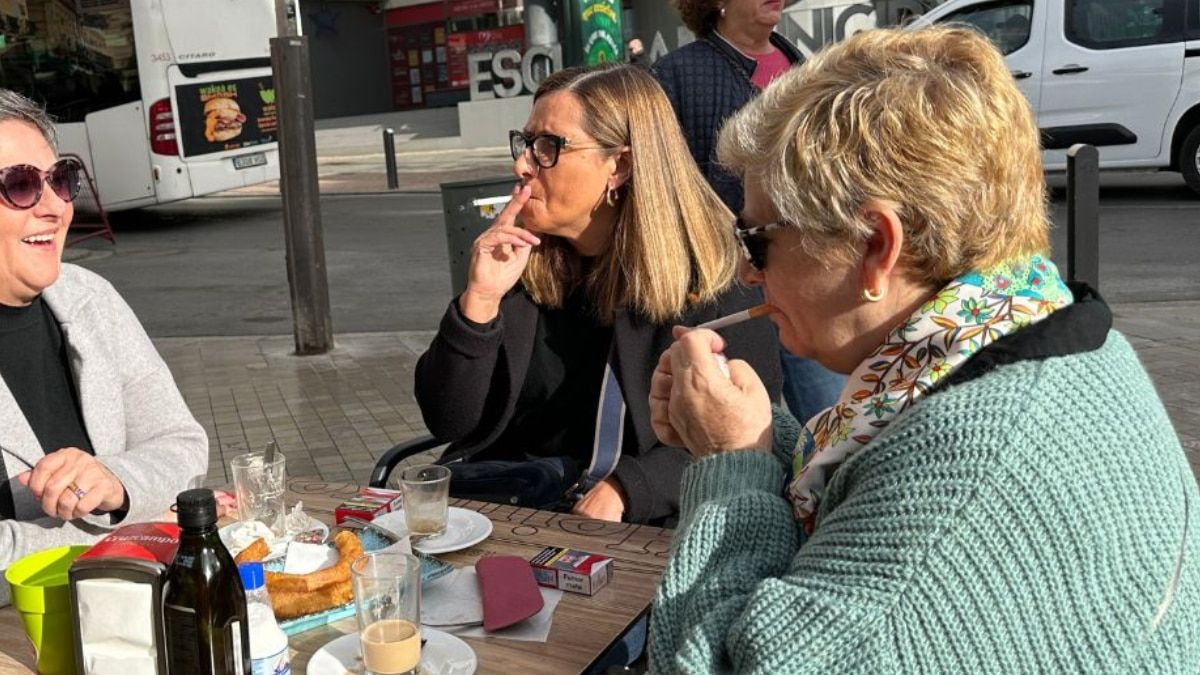 Dos mujeres fumando terraza de una bar