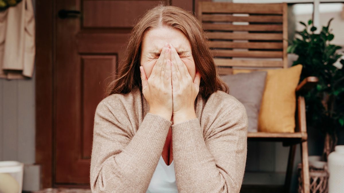 Una mujer llora mientras se tapa la cara con las manos