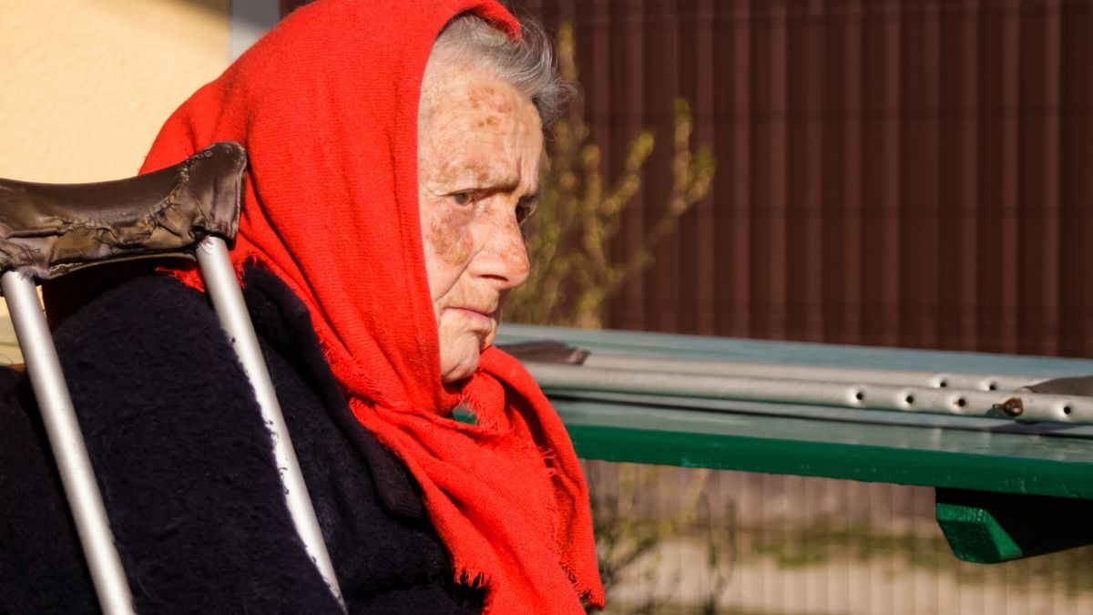 Una anciana al lado de la ventanilla del autobús