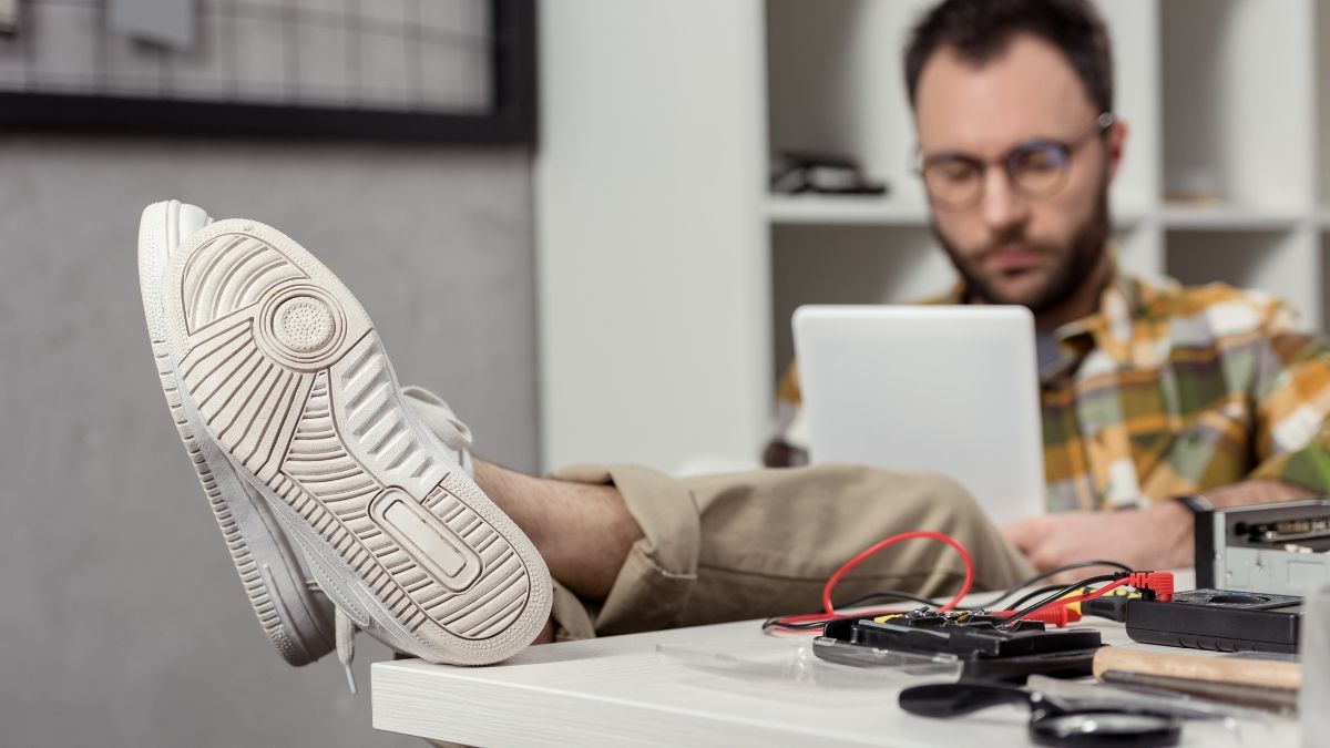Un trabajador de informática con los pies en la mesa