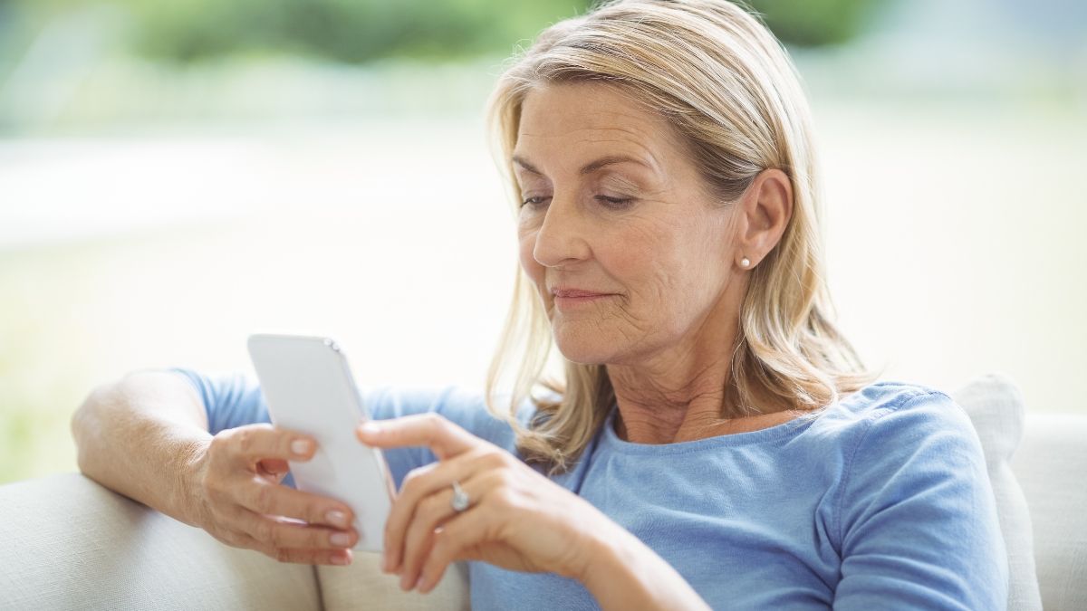Una mujer mayor mirando su teléfono móvil