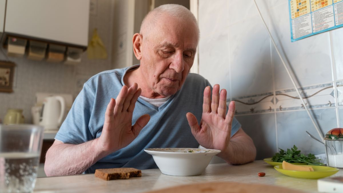 Un hombre rechazando un plato de comida