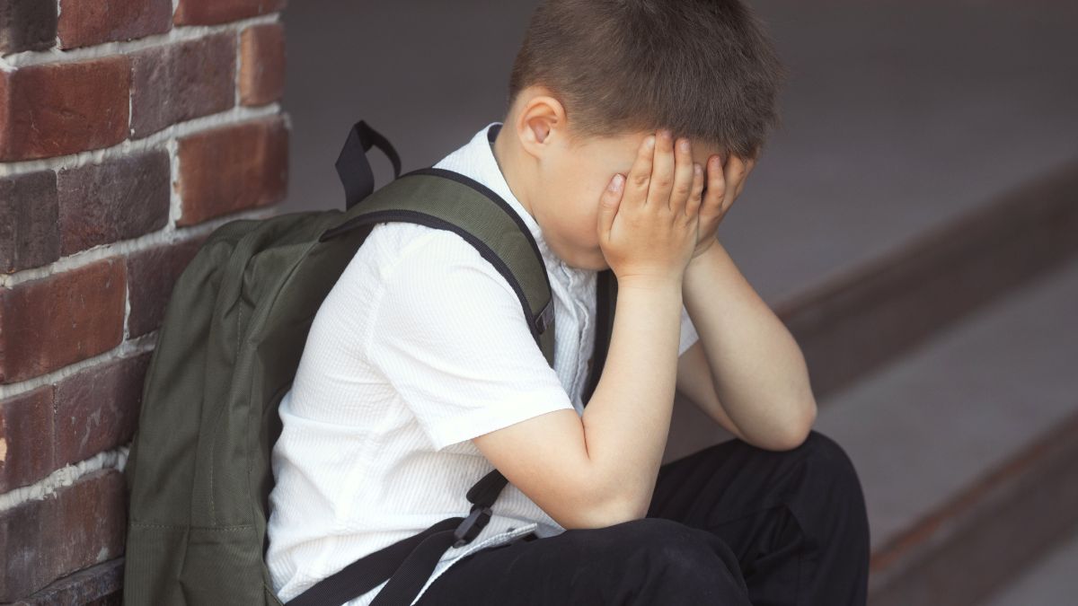 Un niño llorando en la puerta de un colegio
