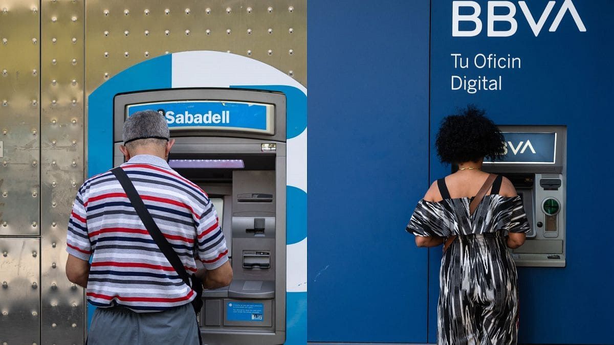 Dos personas utilizan cajeros del Banco Sabadell y BBVA.