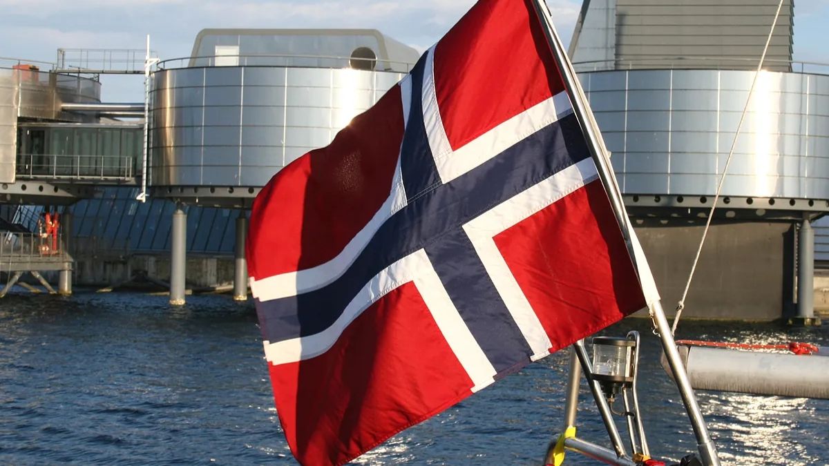 Una bandera de noruega situada frente a unos barriles